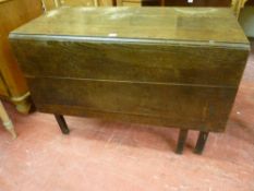AN ANTIQUE OAK GATE LEG DINING TABLE on square canted corner supports
