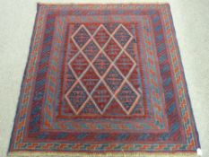 A TRIBAL CAZAK RUG, blue and red ground with central repeating diamond pattern and multiple