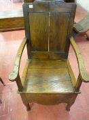 AN ANTIQUE OAK BOX SEAT ARMCHAIR with panel back and shaped apron, 101 cms high, 61 cms wide (