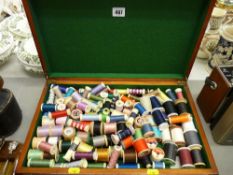 Vintage wooden case full of reels of cotton and thread