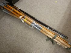 Three vintage fishing rods and a quantity of walking sticks