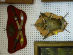 Two decorative wall mounts of arms and armour