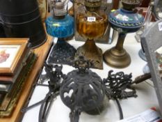Two iron based oil lamps, brass stemmed lamp and a Continental ceiling lamp