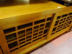 Modern light wood entertainment cupboard with trellis front sliding doors