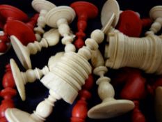 Vintage stained and carved bone chess pieces in a wooden box
