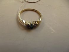 Yellow metal dress ring set with emerald and diamo