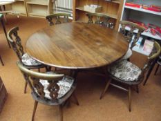 Ercol table with six carved chairs,