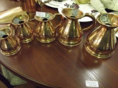 Set of five graduating copper haystack jugs, from