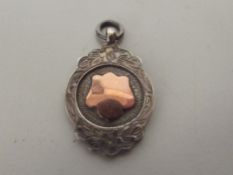 Silver fob with gold shield