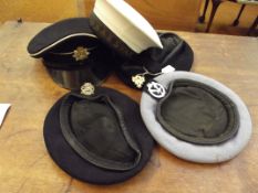 Three military berets, a peak hat together with a