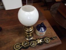 Brass oil lamp, horse brasses together with a whis