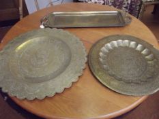 Two large brass wall chargers together with an Eas