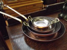 Two copper and brass frying pans together with two
