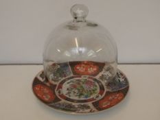 Glass bell shaped cloche on a Chinese charger