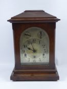An Oak Mantle Chiming Clock, the clock having a German 18 cms movement, silvered face and Roman