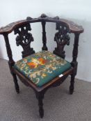 An Antique Oak Corner Chair, with elaborate carving to chair back and arm rests.