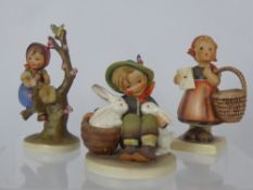 Two West German Goebel Figurines, including girl with a basket, boy with rabbits and girl in a