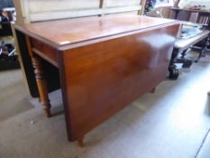 A Victorian Mahogany Drop-Leaf Dining Table. The table on turned legs, approx 54 x 110 x 72 cms (155