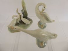Lladro, two figures of Geese, together with a Nao group of geese.