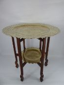 A Chinese Hard Wood Occasional Table, with tiered decorative brass trays depicting chasing dragons.