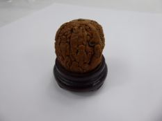A Vintage Figural Chinese Hand-Carved Walnut Shell on wooden stand, approx 3.5 cms (without stand).