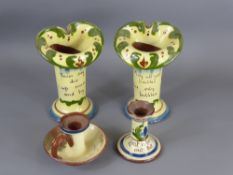 Four items of Torquay Ware, including two vases and two candle holders.