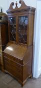 A Burr Walnut Drop-Down Secretaire, with glazed-fronted bookcase to top (two shelves) and four