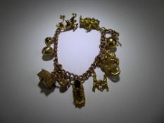A 9 ct Yellow Gold Charm Bracelet, with approx 13 charms, ten hallmarked, approx 38 gms.