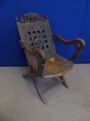 A 19th Century Chinese Hard Wood Folding Chair, the chair carved with dragons and bats.