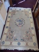 A Washed Chinese Wool Carpet depicting dragons and flowers to centre and at each corner, on a grey