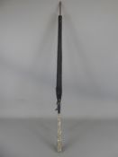 An Elegant Victorian Silver Topped Black Parasol. The parasol fabric depicting gold lilies and the
