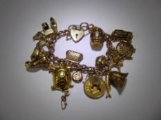 A 9ct Gold Charm Bracelet, with seventeen hallmarked charms and a Victorian 1875 Shield Back Half