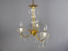 A Pair of Gilded-Brass and Glass Chandeliers with three twisted arms and bulbs and decorated with