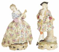 A pair of Continental porcelain figurines, early 20th century the lady holding a fan dressed in a