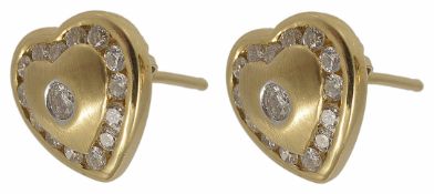 A pair of small contemporary heart shaped diamond set earrings with small central diamond and a