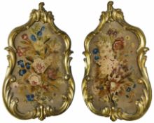 A pair of early 19th Century gilt framed chenille work panels of floral design in ornate gilt wood