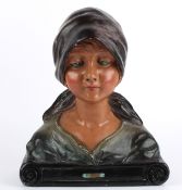 A French Art Deco bust of a female, 1930's wearing a headscarf, and shawl, upon a scroll incised