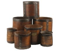 A collection of seven 19th and early 20th century wooden grain measures, each with metal banding,