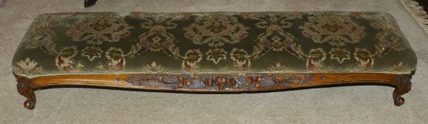 A Victorian mahogany footstool, of long proportions with upholstered upper section above foliate