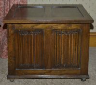 An oak coffer, 20th century of small proportions with two panelled top and two linen fold carved