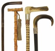 Three late 19th/early 20th century walking canes and later umbrella including a walking cane with