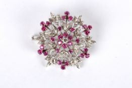 A Continental ruby and diamond set floral circular cluster brooch with central diamond and ruby