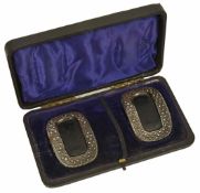 A cased set of early 19th cut steel and leather buckles of oval form with cut steel border and