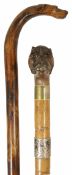 Two late 19th century walking sticks the first with wooden shaft terminating with a carved handle in