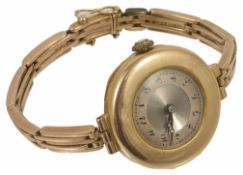 An Art Deco 9ct gold ladies wristwatch on gold bracelet the circular dial within a wide gold mount