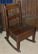 An oak child's rocking chair, 19th century the slatted back above panelled seat with a side drawer