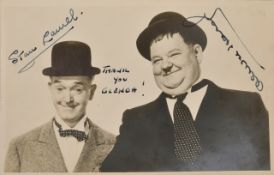 A signed black and white publicity photograph of Laurel and Hardy signed in black ink by Stan Laurel