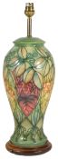 A Moorcroft tubelined table lamp, of baluster form with green ground with leaf decoration