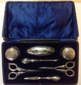 A George V silver mounted manicure suite, Birmingham 1921 comprising of a nail buffer, scissors,
