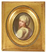 An oval porcelain painted miniature of a girl, early 20th century modelled looking over her left